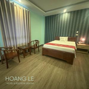 a bedroom with a bed and two chairs and a table at Hotel Hoàng Lê Tiền Hải in Tiền Hải