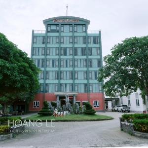 a large blue building with a statue in front of it at Hotel Hoàng Lê Tiền Hải in Tiền Hải
