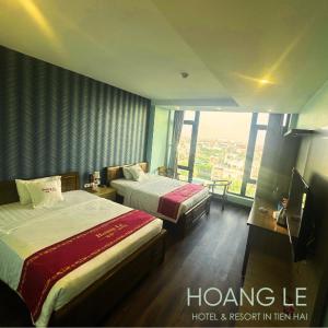 a hotel room with two beds and a large window at Hotel Hoàng Lê Tiền Hải in Tiền Hải +6 photos