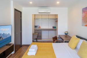 Un dormitorio con una cama y una mesa y una cocina. en 3BDR Townhouse in Laguna Park, en Bang Tao Beach