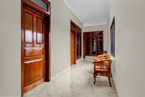 um corredor com uma porta de madeira e uma cadeira em OYO 94920 House Of Elea Minggiran em Timuran