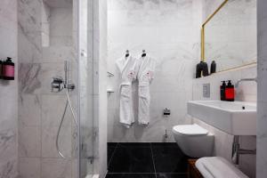 a bathroom with a shower and a toilet and a sink at Nordoy Hotel - Fattal Colors in Tel Aviv