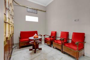 uma sala de espera com cadeiras vermelhas e uma mesa em OYO 94920 House Of Elea Minggiran em Timuran