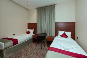 una camera d'albergo con due letti e un tavolo di فندق رفاهية الكرام a Al Khansāk