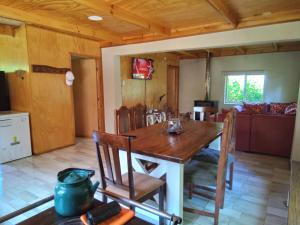 a kitchen and dining room with a wooden table and chairs at Cabaña los sauces in Chile Chico +18 photos