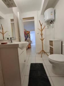 a white bathroom with a sink and a toilet at Logement chaleureux confortable - 2 chambres - Aveline in Petit-Canal +18 photos