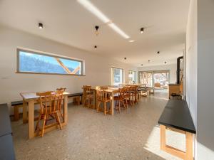 Un comedor con mesas y sillas de madera. en KOČA ODMEV Obolno, en Ivančna Gorica