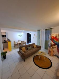 a living room with a couch and a table at Logement chaleureux confortable - 2 chambres - Aveline in Petit-Canal