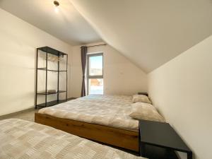 Un dormitorio con dos camas y una ventana. en KOČA ODMEV Obolno, en Ivančna Gorica