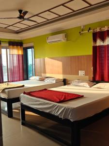 Habitación con 3 camas y techo. en Moonstar guesthouse, en Māvalli