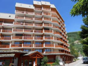 Un edificio alto con balcones naranjas en una calle. en Studio 4 pers, balcon sud, Les Deux Alpes - FR-1-516-12, en Les Deux Alpes
