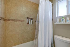 a bathroom with a shower with a white shower curtain at 5 Mi to Jack London Square Apt with Shared Yard in Alameda +19 photos