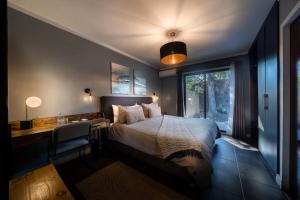 a bedroom with a bed and a desk and a window at Santa Teresita Boutique Hotel in San Fernando