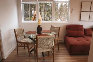 a living room with a table and chairs and a couch at Refuge du Fjord in Saguenay