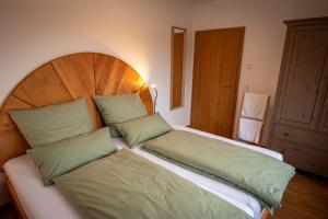 a bedroom with a large bed with green pillows at Ferienwohnung Weitblick im Dahner Felsenland in Bruchweiler-Bärenbach