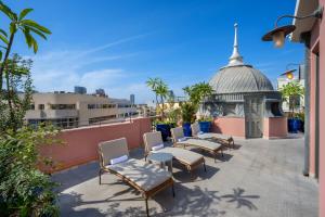 a row of chairs on the roof of a building at Nordoy Hotel - Fattal Colors in Tel Aviv