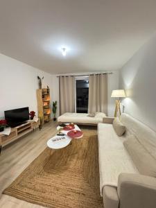 Cozy F2 Apartment La Queue en Brie في La Queue-en-Brie: غرفة معيشة بها أريكة وطاولة