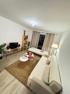 Cozy F2 Apartment La Queue en Brie في La Queue-en-Brie: غرفة معيشة بها أريكة وطاولة