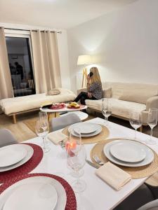 Cozy F2 Apartment La Queue en Brie في La Queue-en-Brie: غرفة معيشة مع طاولة مع أطباق وكؤوس للنبيذ