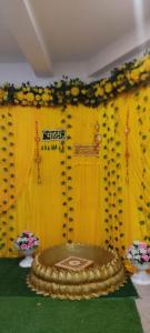 a stage with a yellow curtain and a cake at Jakusst guest house in Gwalior