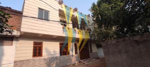 a house with colorful flags on the side of it at Jakusst guest house in Gwalior