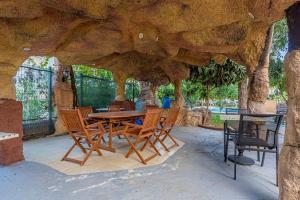 a wooden table and chairs sitting under a stone structure at Melissas Suites Lara in Antalya