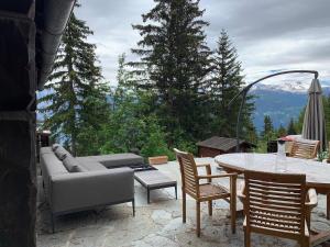 Arni AlpCrans-Montana Chalet dans la nature ski in ski out的天井配有沙发和桌椅