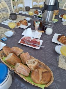a table with a plate of bread and pastries on it at Chambres D'hotes Les Lits Marins in La Cotinière