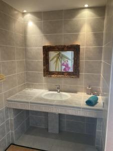 a bathroom with a sink and a mirror at Chambres D'hotes Les Lits Marins in La Cotinière