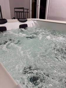 uma banheira de hidromassagem cheia de água num quarto em Aspra Mare House em Aspra
