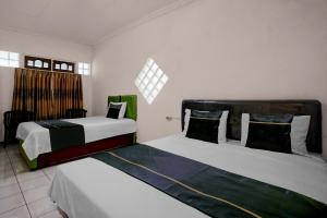 Ένα ή περισσότερα κρεβάτια σε δωμάτιο στο Hotel O Embun Pagi & Villa Resort Batu