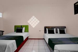 Ένα ή περισσότερα κρεβάτια σε δωμάτιο στο Hotel O Embun Pagi & Villa Resort Batu +21 φωτογραφίες