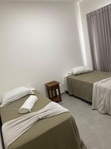 una camera d'albergo con due letti e un tavolo di Hotel Terras a Teixeira de Freitas