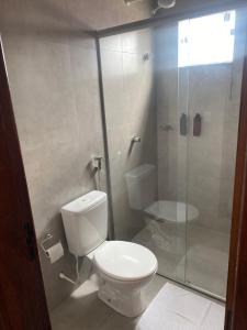 un bagno con wc e doccia in vetro di Hotel Terras a Teixeira de Freitas