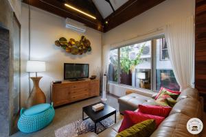 un soggiorno con un divano e una TV di Lannatika Villa a Chiang Mai