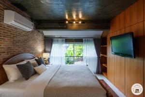 una camera con letto e TV a parete di Lannatika Villa a Chiang Mai