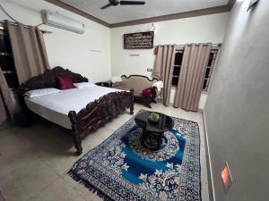 a bedroom with a bed and a table and a rug at Rooms in appartment by LUXE in Mysore +17 photos