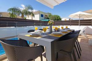 einen Tisch mit Stühlen und einen Tisch mit Brille darauf in der Unterkunft Elite Luxury Villa in Paralimni