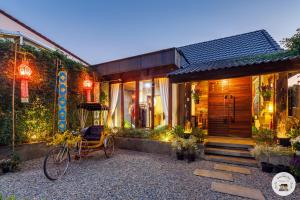 a house with a bike parked in front of it at Lannatika Villa in Chiang Mai