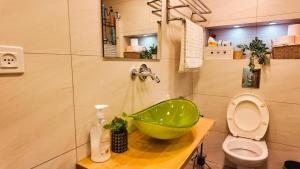 Un baño con un lavabo verde y un inodoro. en Leo Apartment by the sea Eilat, en Eilat