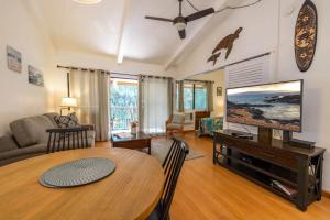 een woonkamer met een tafel en een flatscreen-tv bij Hono Kai Resort C9 in Wailuku