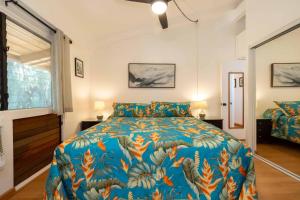 een slaapkamer met een kingsize bed met een kleurrijk dekbed bij Hono Kai Resort C9 in Wailuku +25 foto's