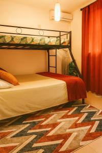 a bedroom with a bunk bed and a rug at Grand Baie Holiday Apartment in Grand Baie