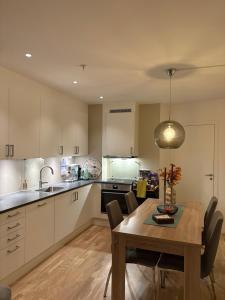 Una cocina con una mesa de madera y un comedor. en Sunside apartment 205, en Trondalen