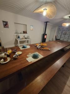 uma grande mesa de madeira com comida em cima em Sous le tilleul em Saint-Georges