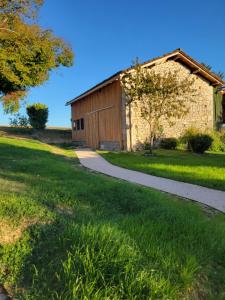 um caminho que leva a um celeiro com um edifício em Sous le tilleul em Saint-Georges