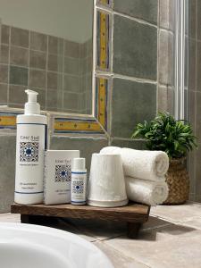 a bathroom counter with towels and a bottle of soap at Logis Hôtel La Bastide des Monges in Nyons +113 photos