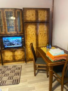 une salle à manger avec une table et une télévision dans l'établissement Pokoje na wynajem "Pod Lasem", à Balice