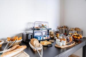 a table with bread and other foods on it at Hôtel La Maison des Croisades - Au pied des Remparts in Aigues-Mortes +28 photos
