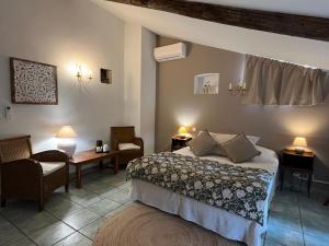 a hotel room with a bed and a chair at Logis Hôtel La Bastide des Monges in Nyons